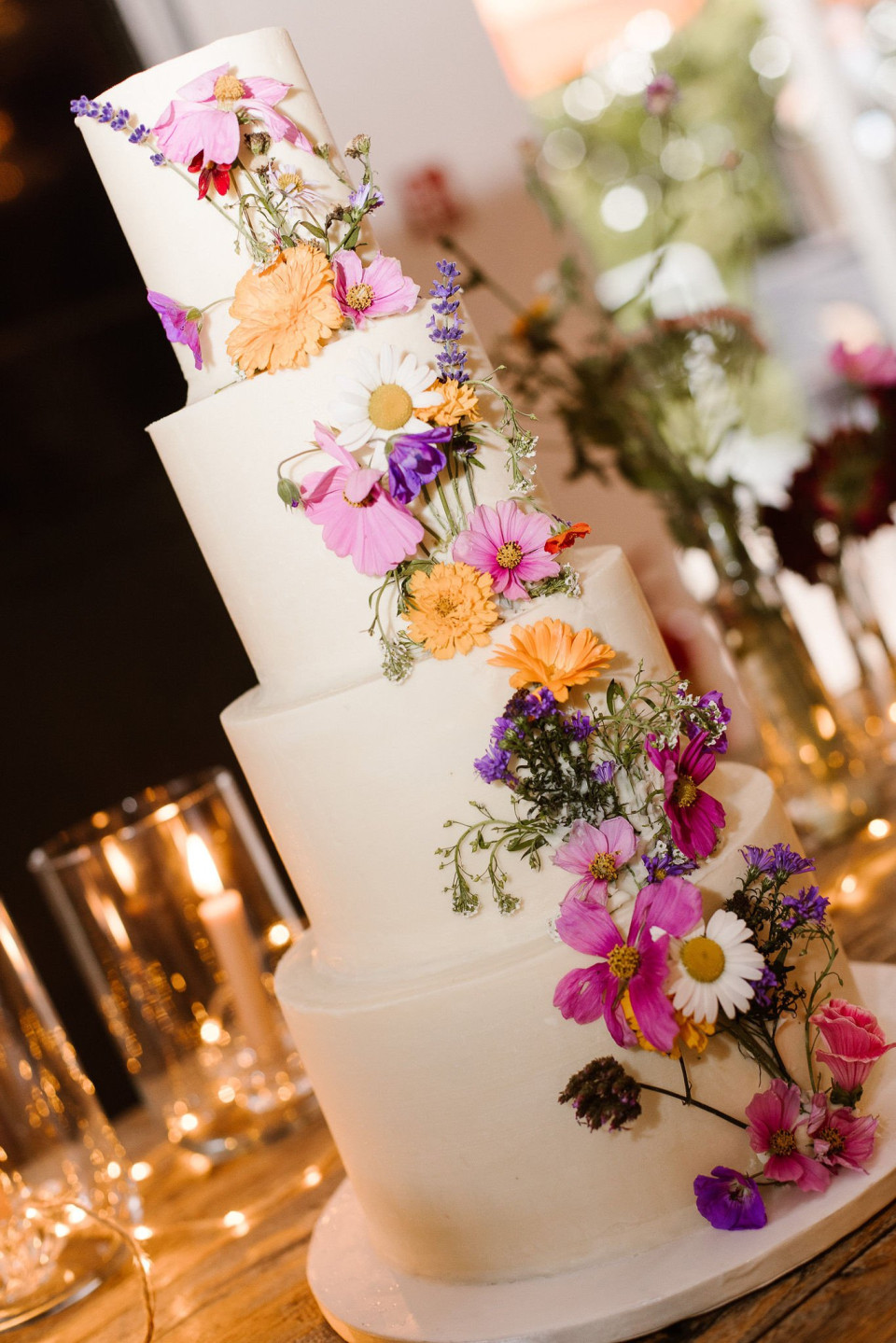 een close-up van een bruidstaart met bloemen erop
