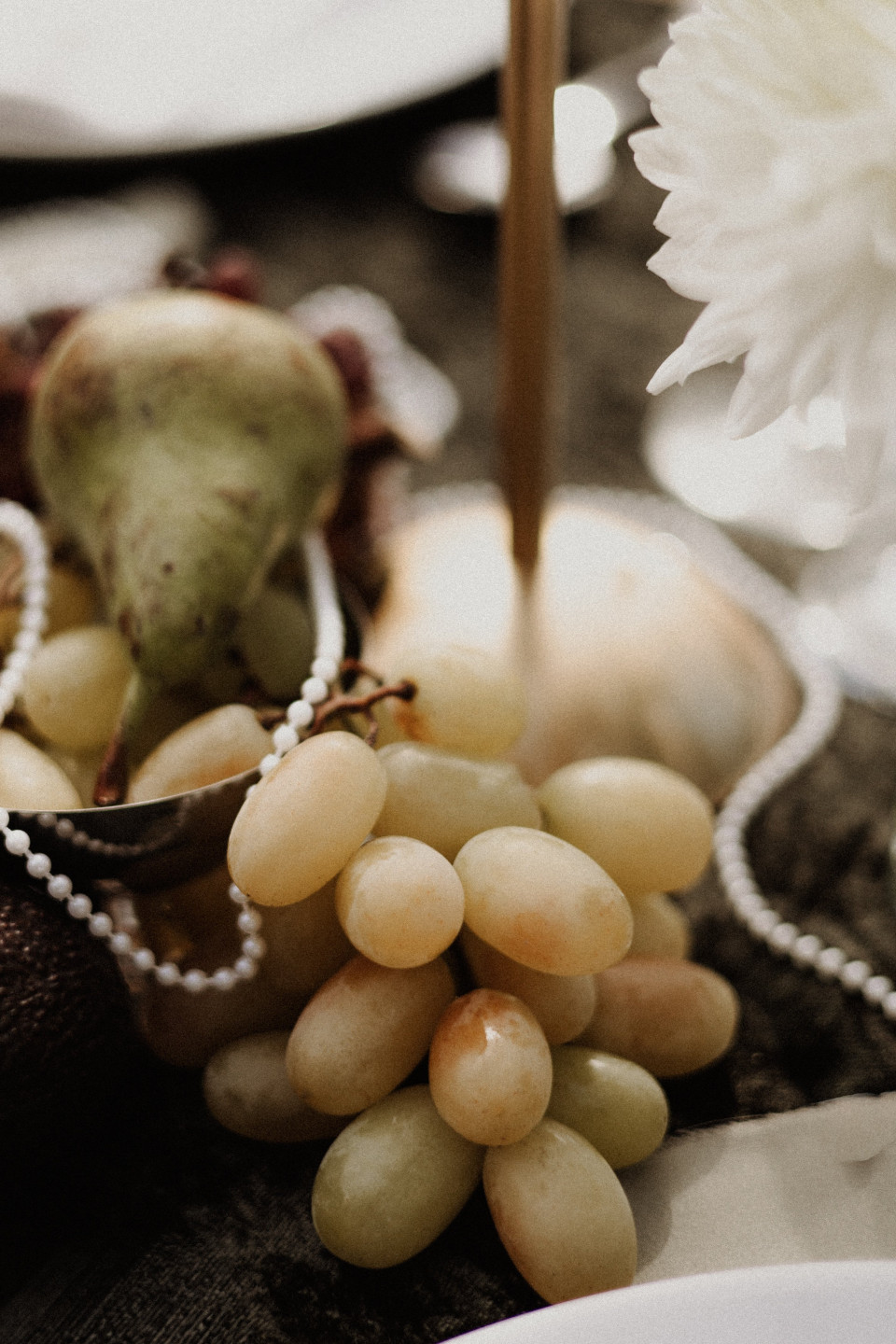 een tros druiven, peren en ander fruit op de tafel