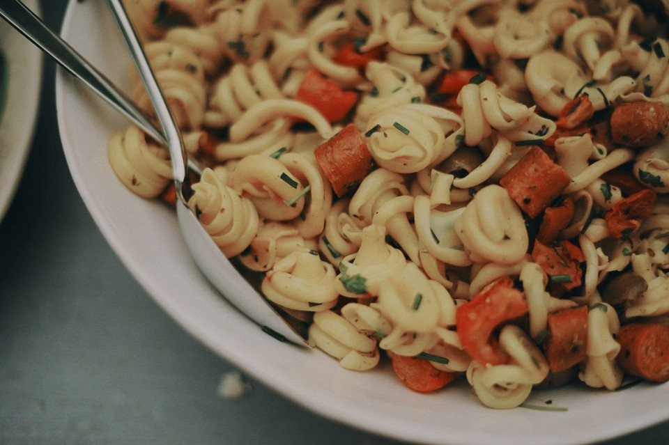 een kom pasta met wortels en andere groenten