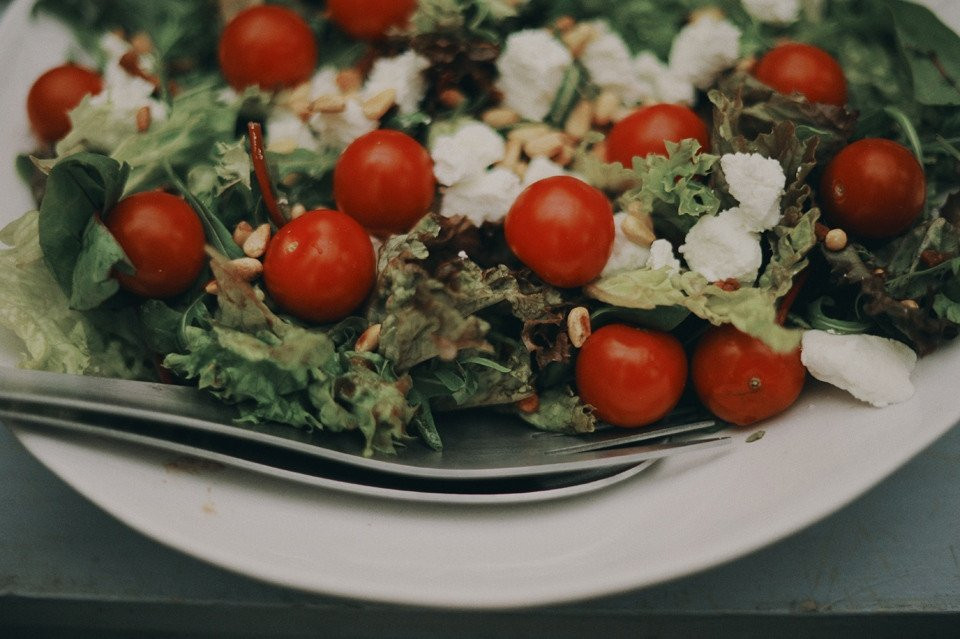 een salade met tomaten, kaas en noten