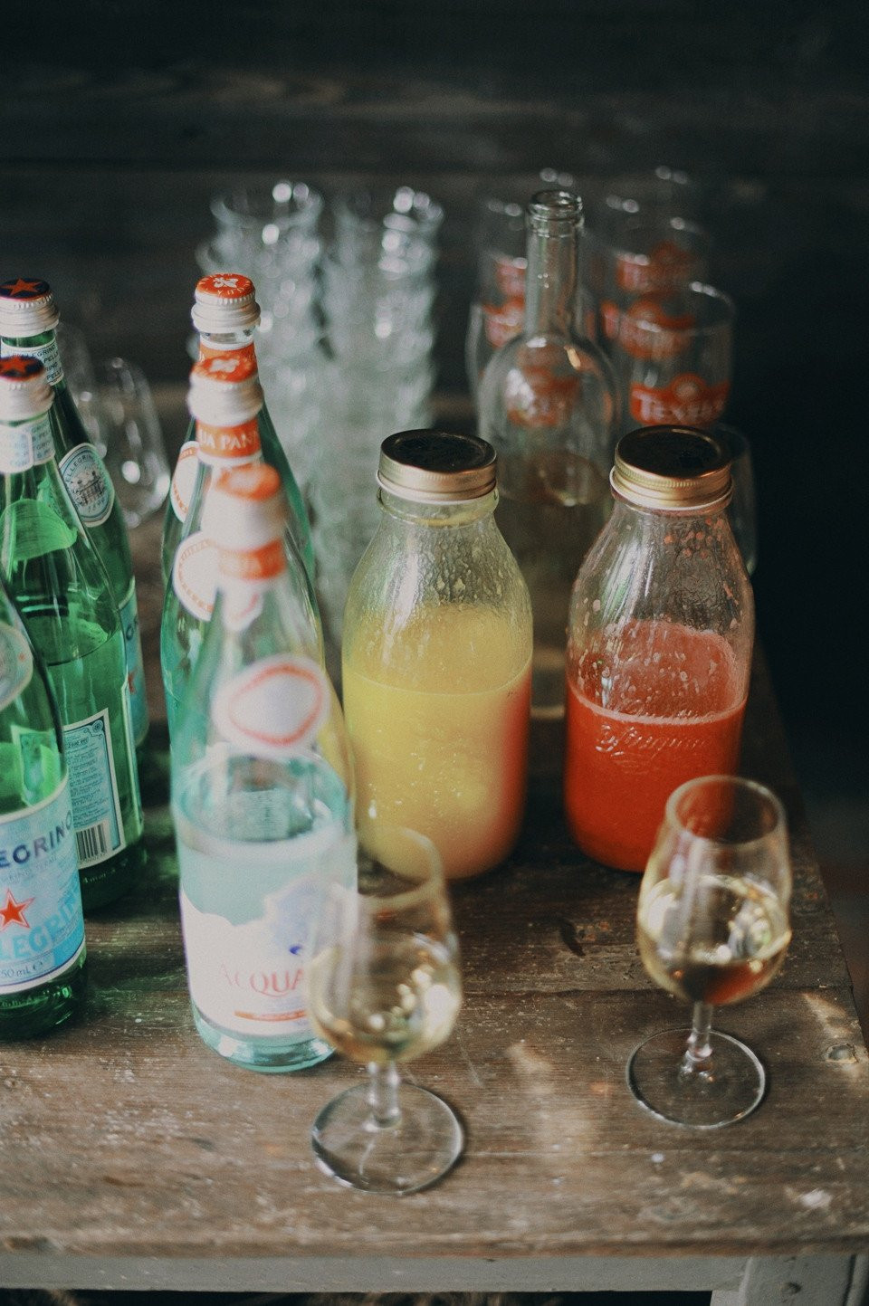 een tafel met flessen sap en glazen
