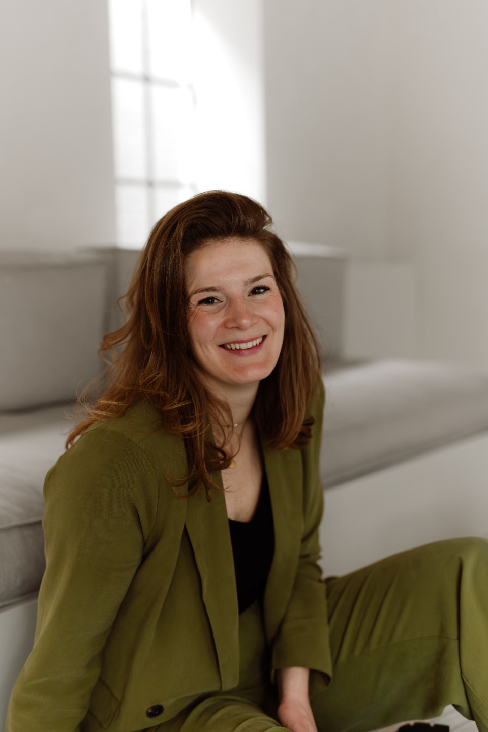 een vrouw die op een bank zit met een afstandsbediening in haar hand