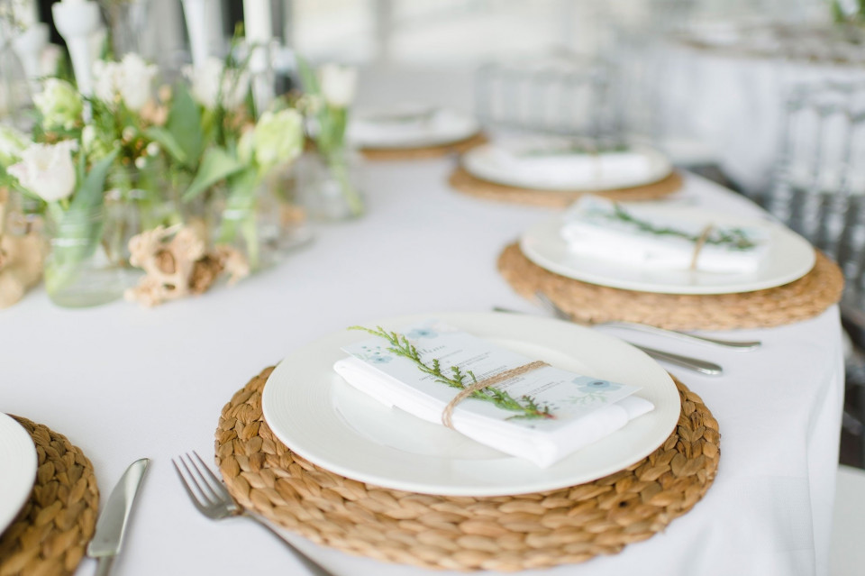 een tafel gedekt met witte borden en tafelgerei