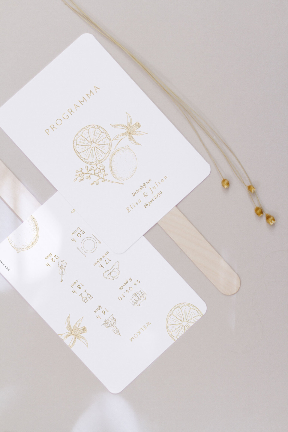 een trouwuitnodiging met gouden folie en een gouden ketting