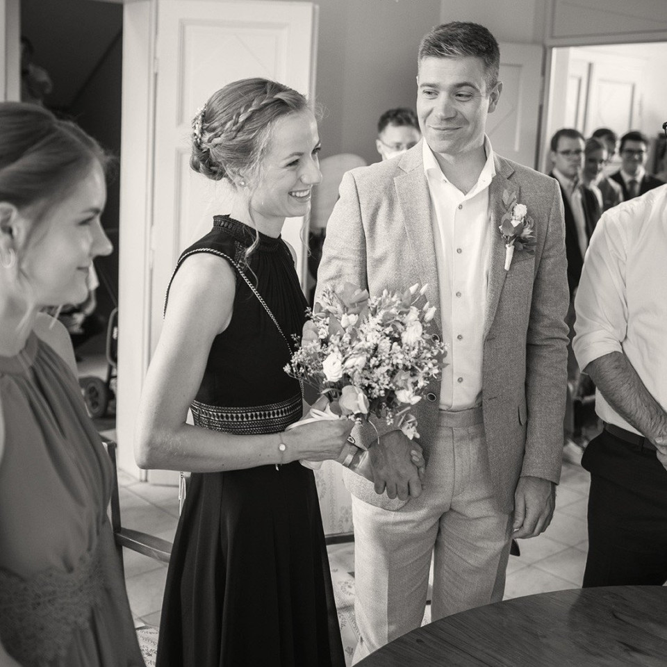 een man en vrouw staan voor een tafel met een bos bloemen