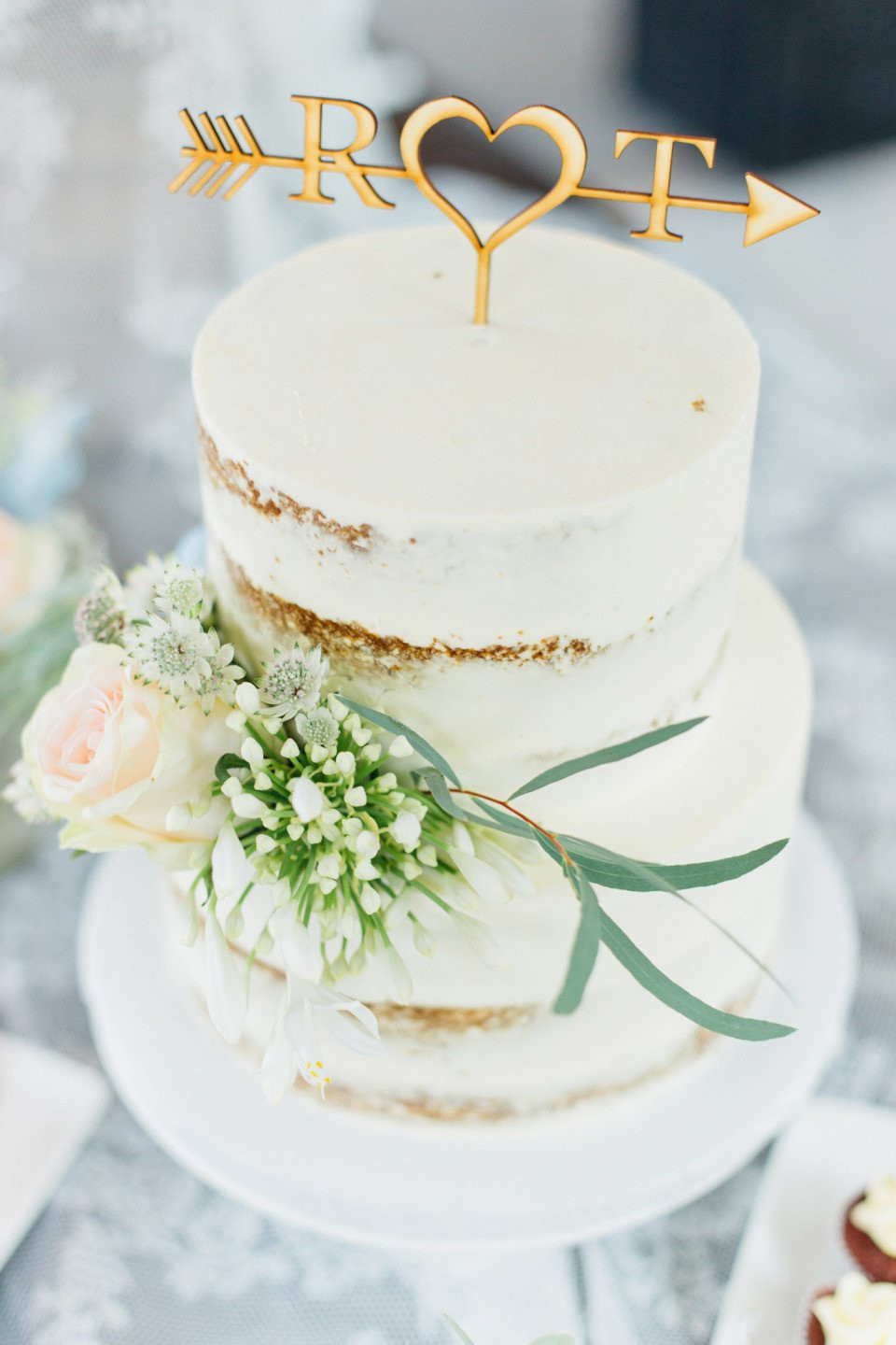 een trouwtaart met een hart- en pijltopper