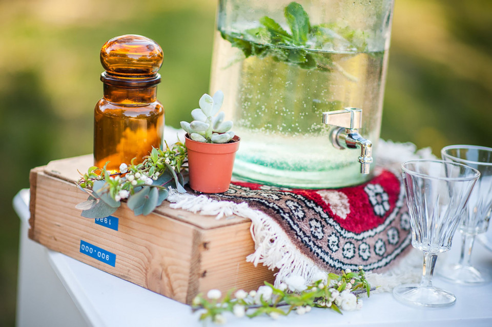 een glazen pot gevuld met water en een plant op een houten tafel