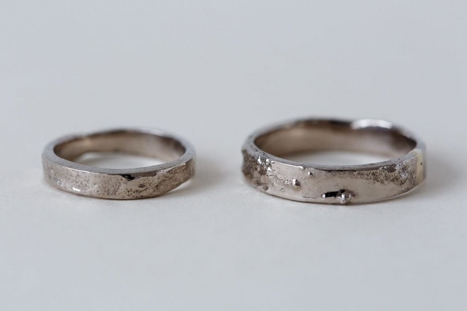 twee zilveren trouwringen met een gestructureerde afwerking
