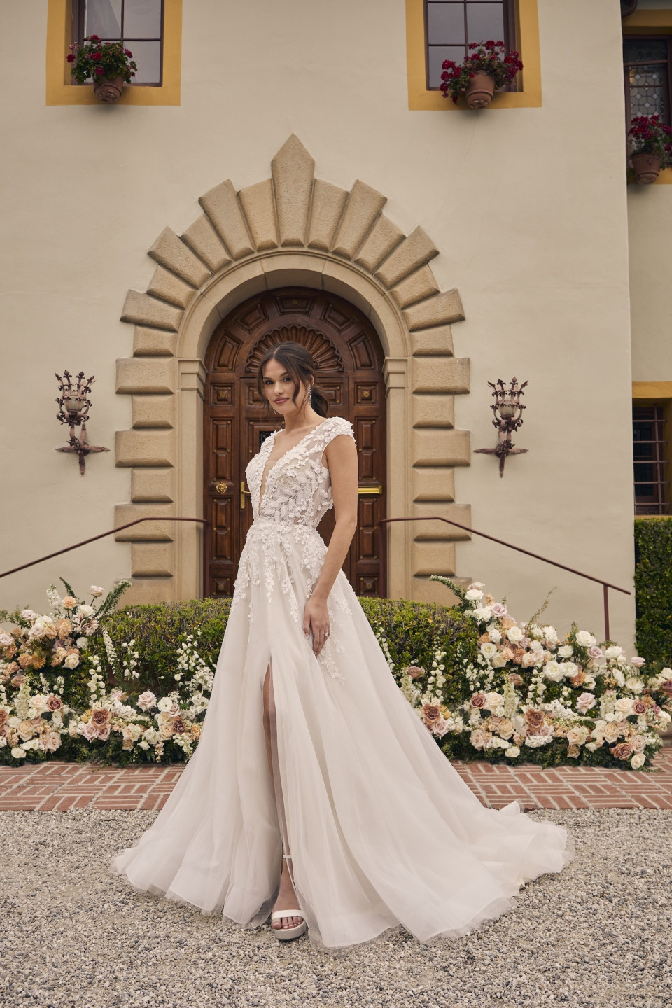 een bruid in een trouwjurk die voor een groot gebouw staat