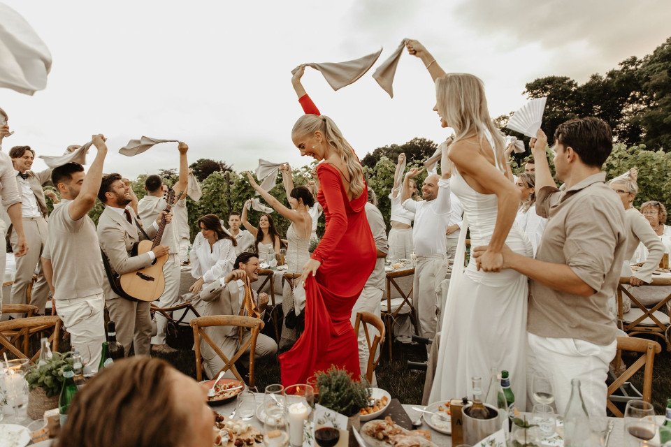 een vrouw in een rode jurk die danst voor een groep mensen