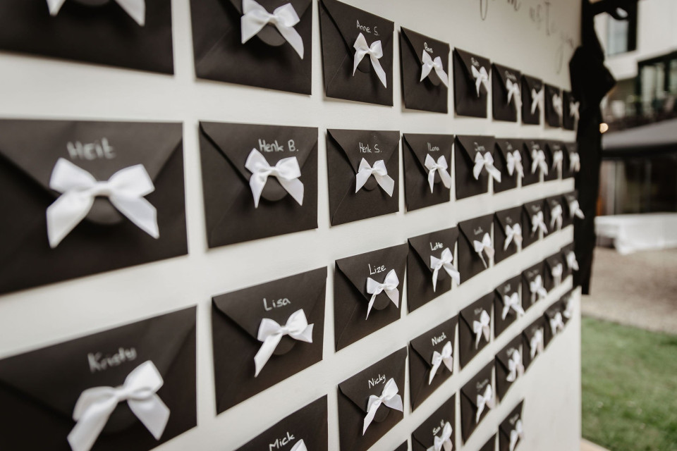 een muur van zwart-witte kaarten met witte strikken erop