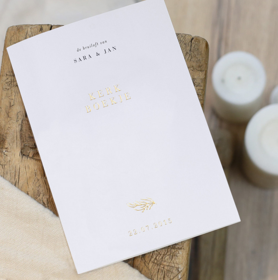 een boek met een gouden folieomslag op een houten tafel