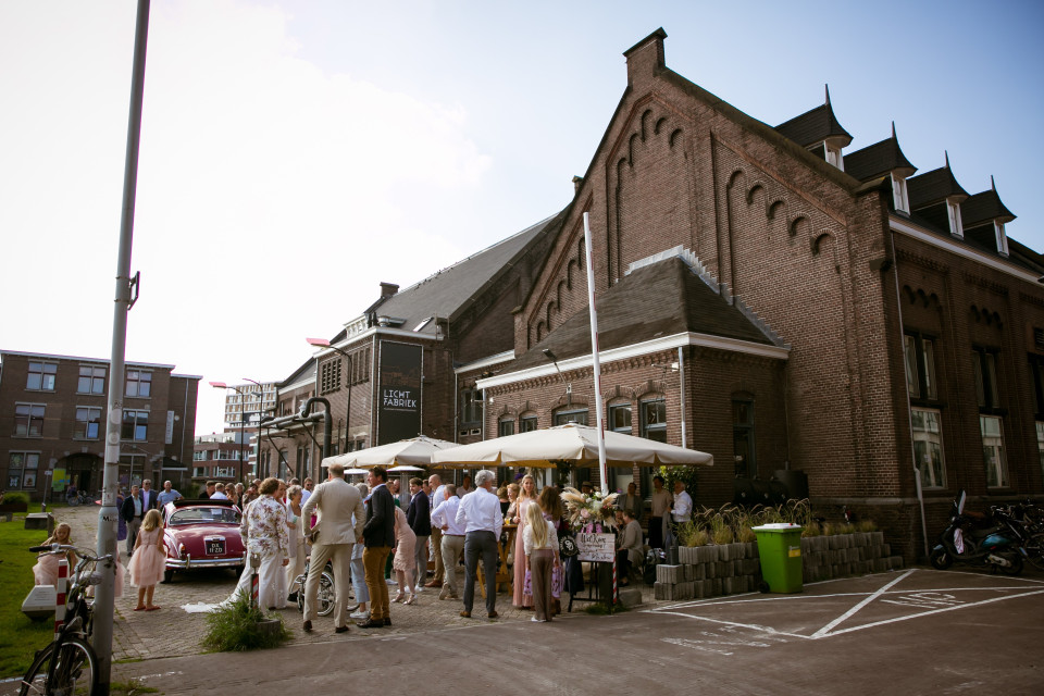 een groep mensen die buiten een gebouw staan