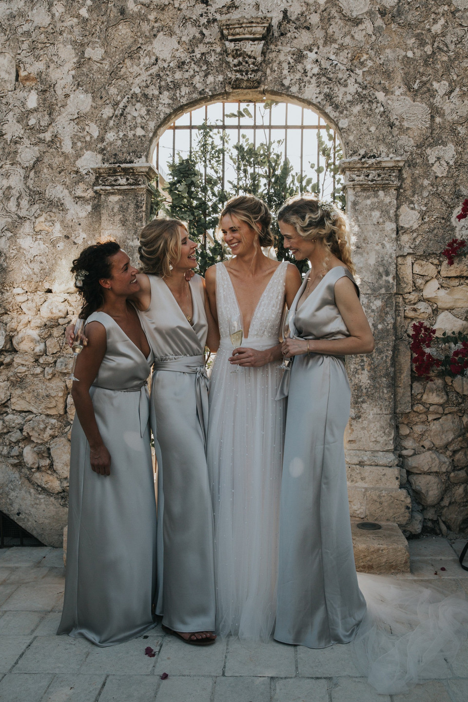 bruidsmeisjes in zilveren jurken poseren voor een foto