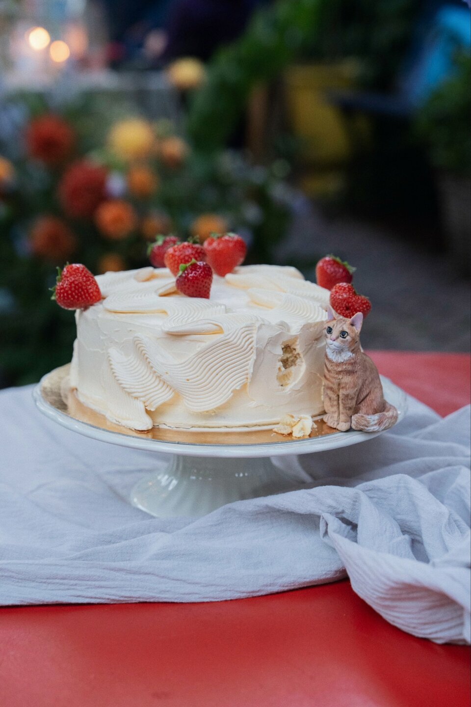 een kattenfiguur dat bovenop een taart zit