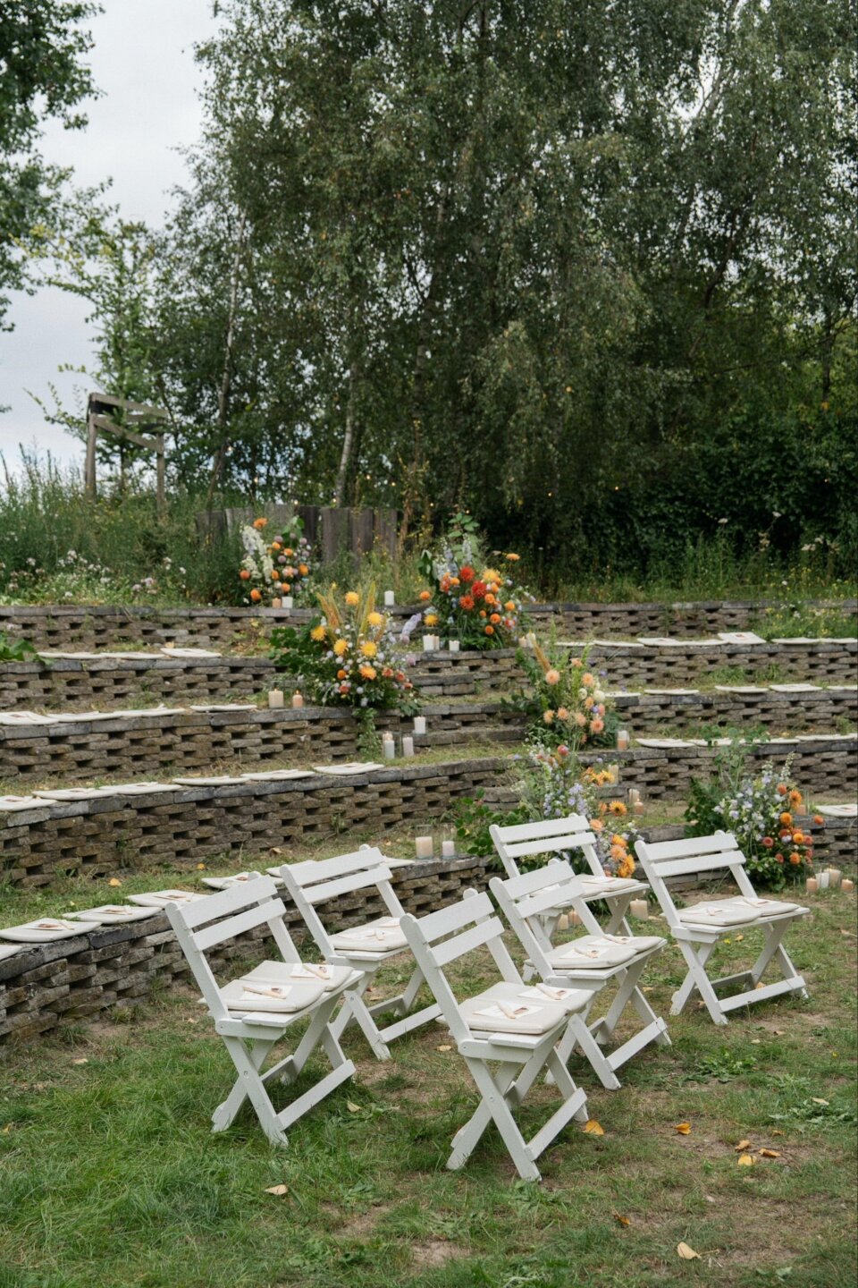 een rij witte opvouwbare stoelen in het midden van een veld