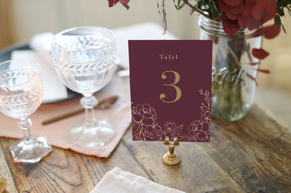 een tafel met een vaas bloemen en een tafelnummer