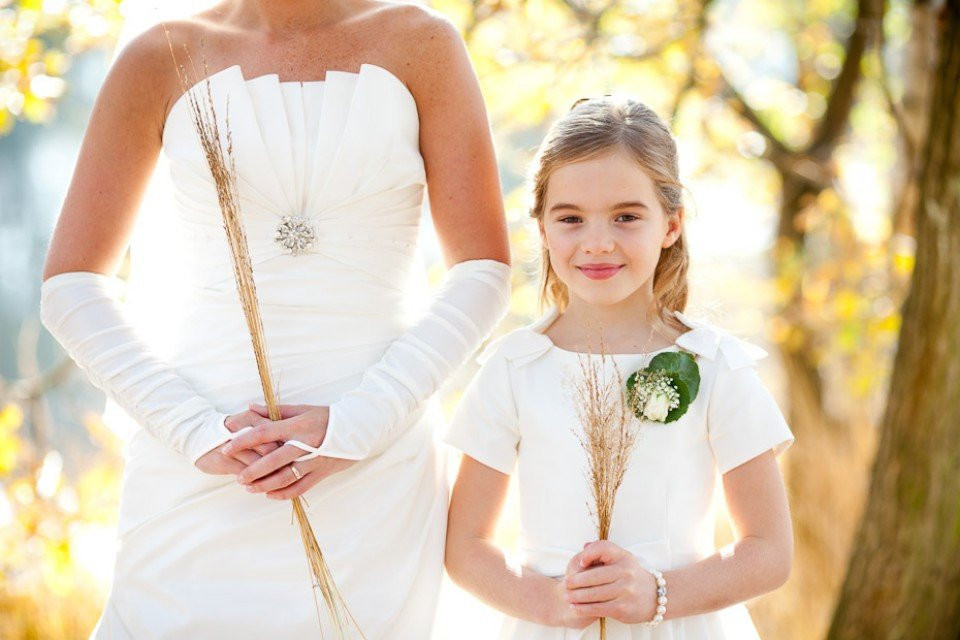 een vrouw en een klein meisje in witte trouwjurken