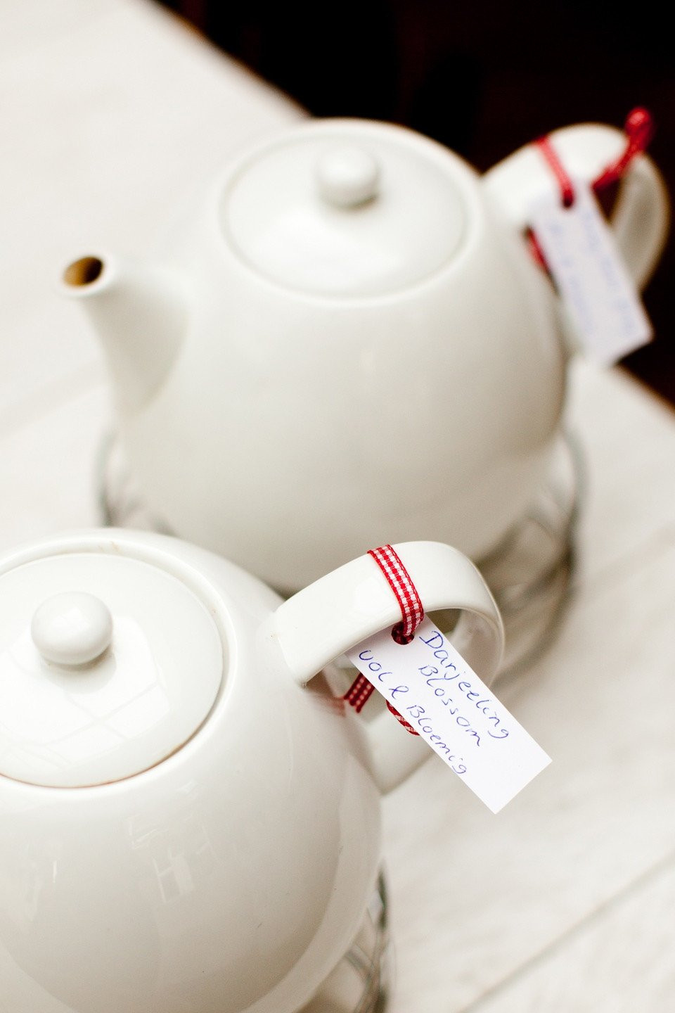twee theepotten met rode en witte linten eromheen