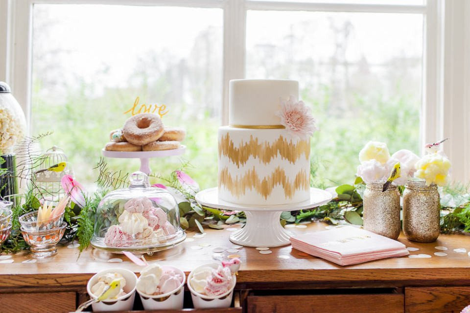 een tafel met een taart, donuts en cupcakes