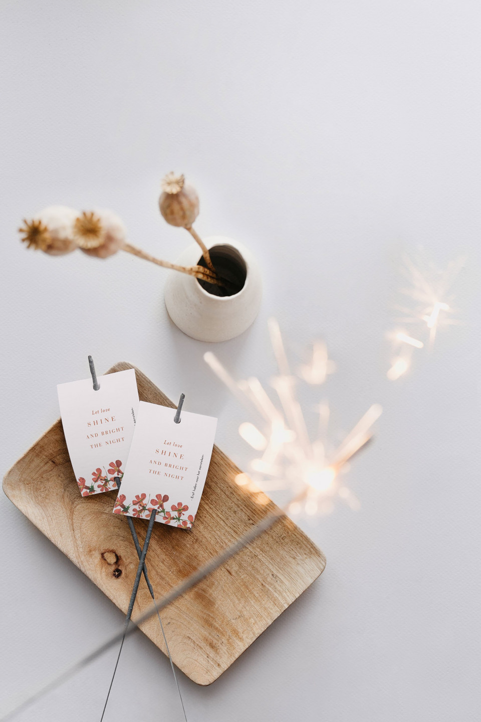 een houten dienblad met twee sterretjes en een vaas met bloemen