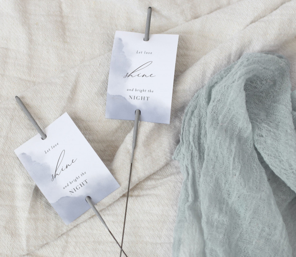 twee trouwlabels op een bed met een wit laken