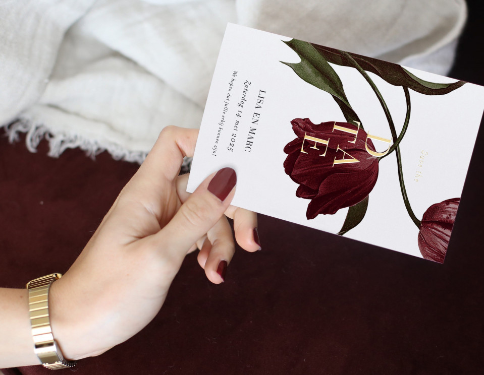 een vrouw die een trouwkaart vasthoudt met een rode bloem