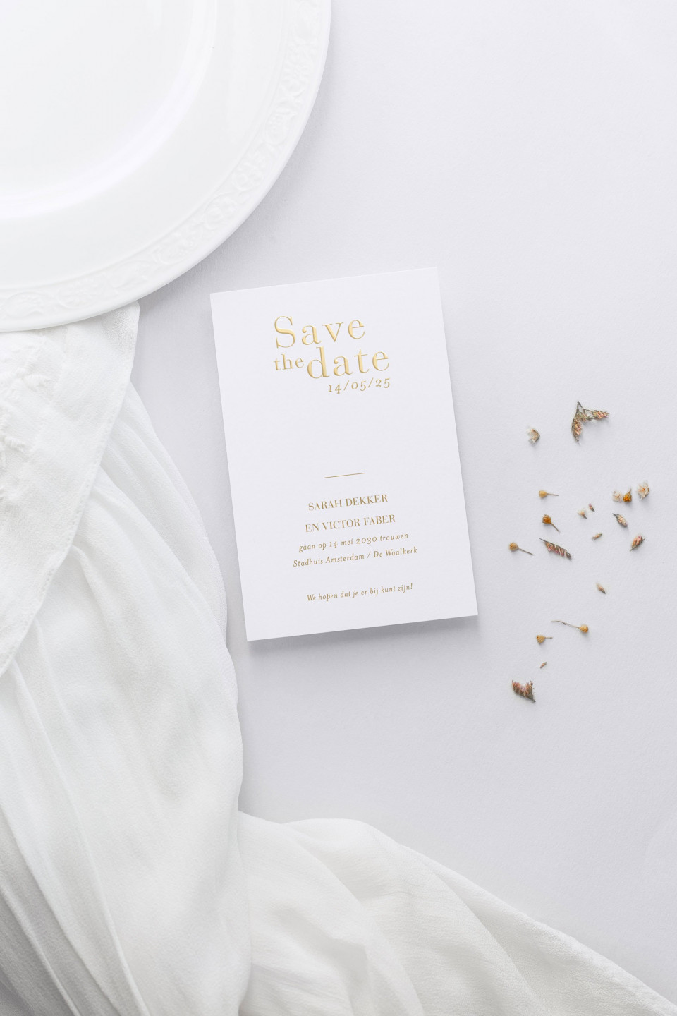 een witte huwelijksuitnodiging met gouden folie