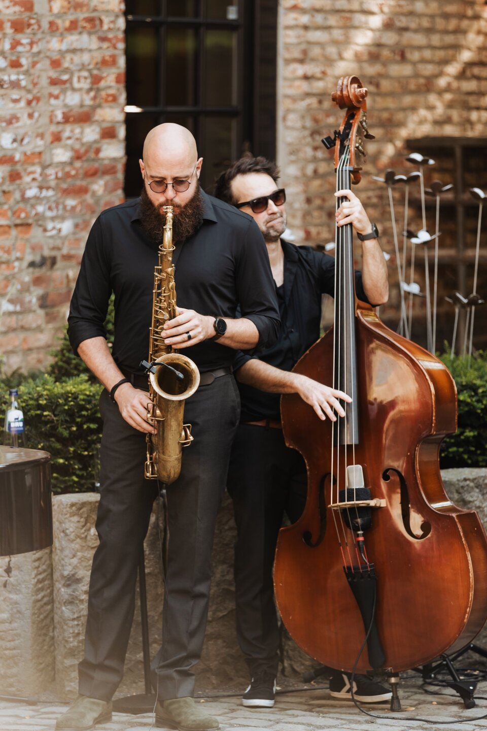 een man met een baard die saxofoon en bas speelt