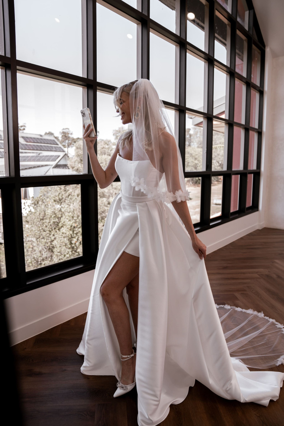 een bruid maakt een selfie voor een groot raam