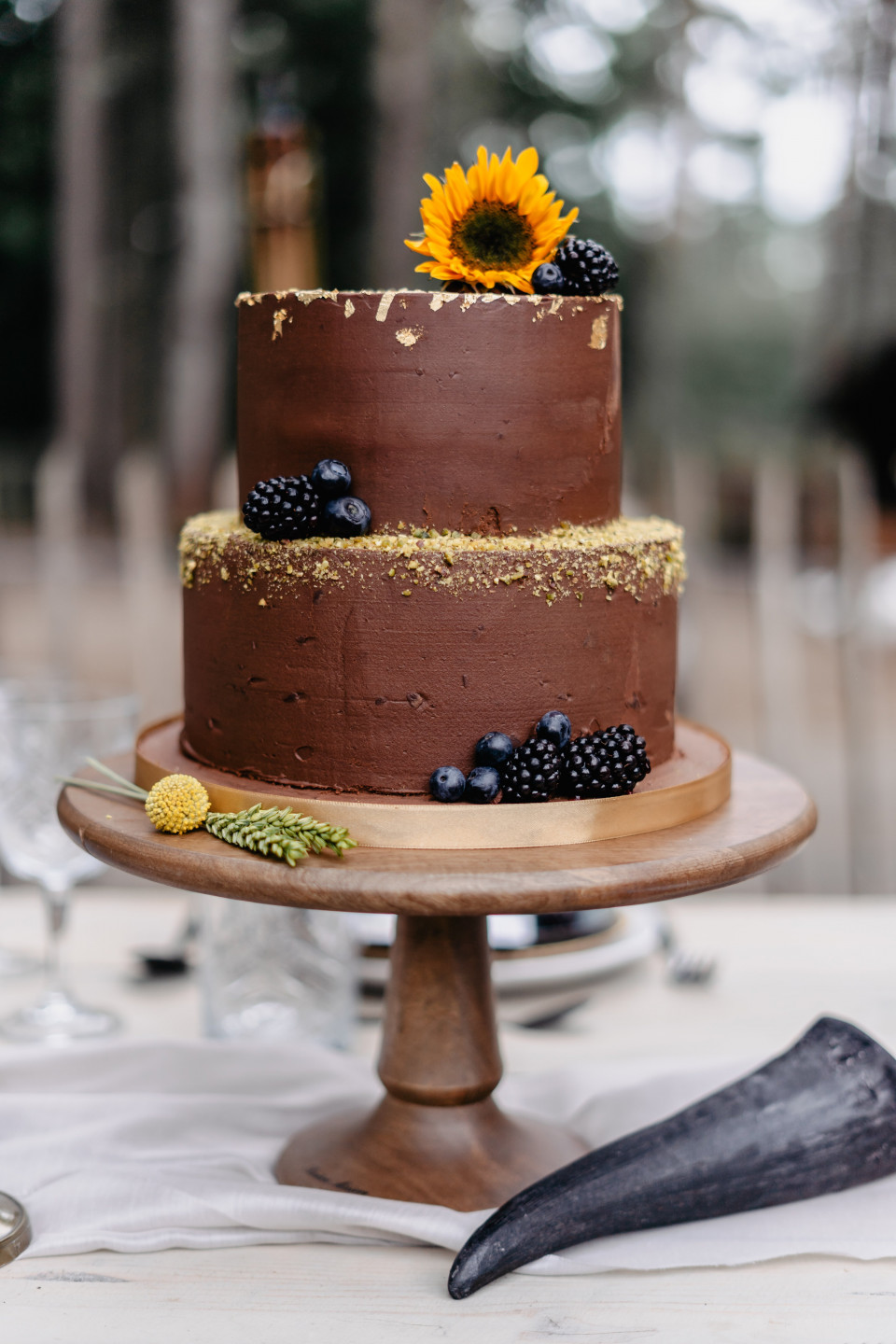 een chocoladetaart met bessen en zonnebloemen erop