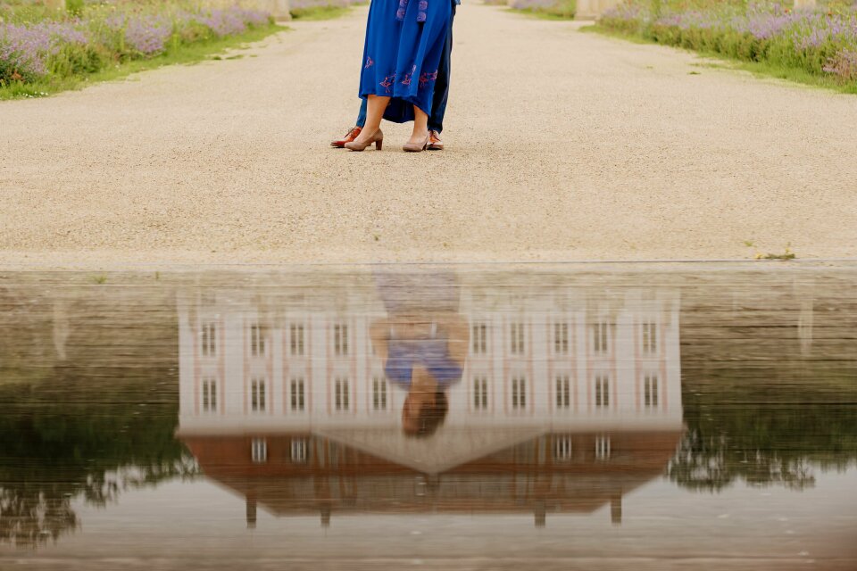 een vrouw in een blauwe jurk die een paraplu vasthoudt