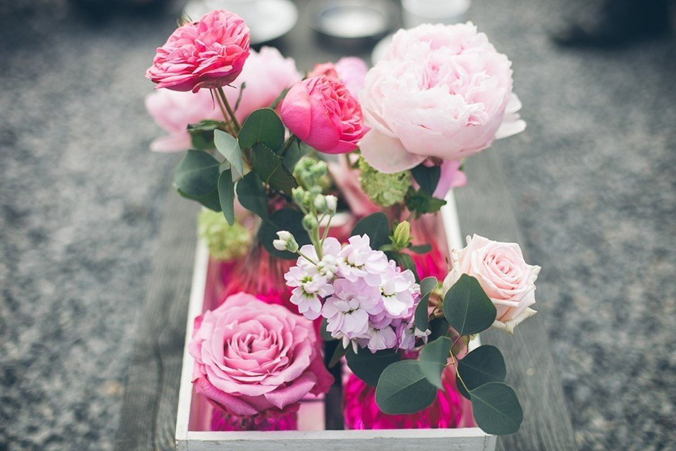 een houten doos gevuld met roze bloemen