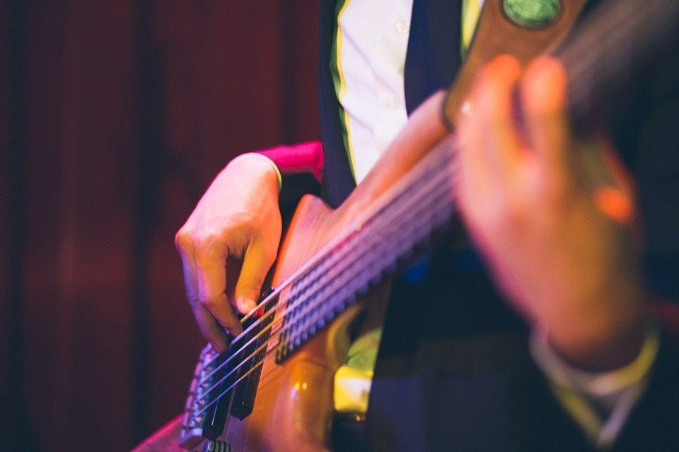 een persoon in een pak die basgitaar speelt