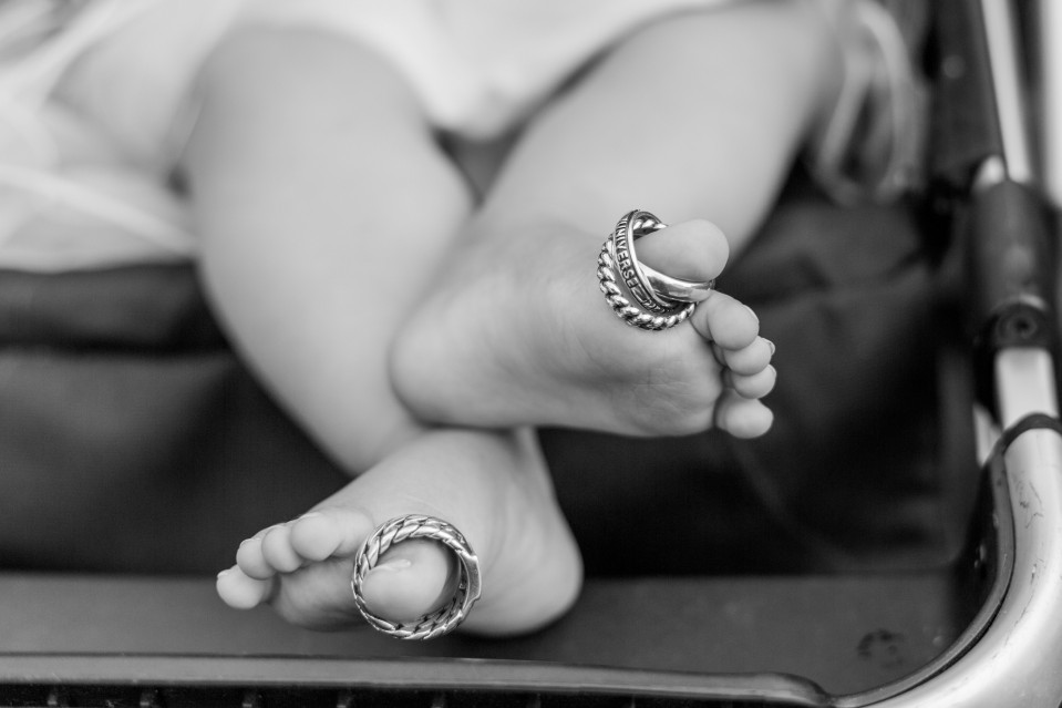 de voeten van een baby in een kinderwagen met ringen erop