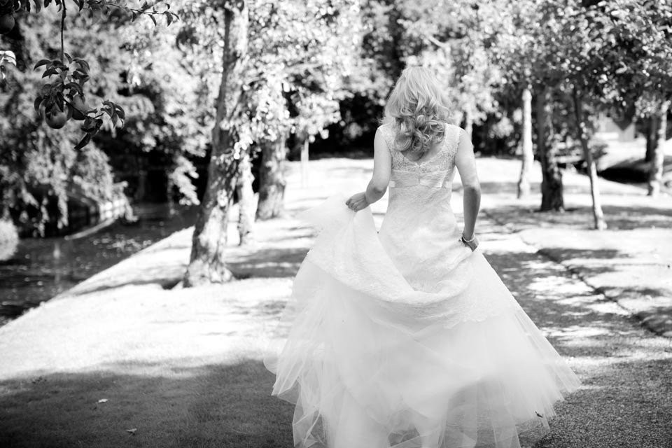 een bruid loopt over een pad in een park