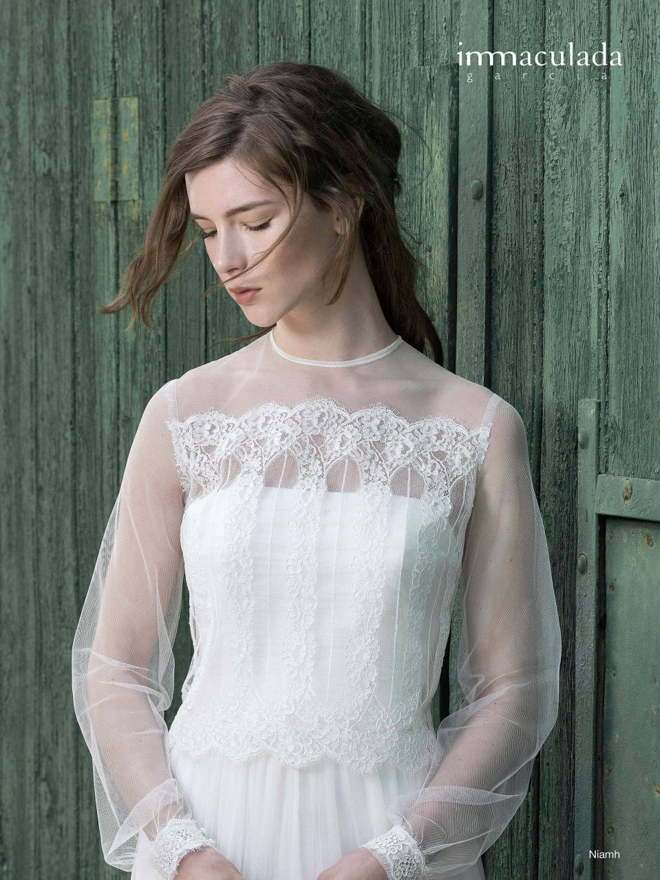 een vrouw in een trouwjurk staande voor een houten deur