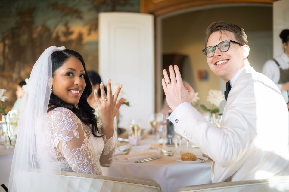 een man en een vrouw die aan een tafel zitten met hun handen in de lucht