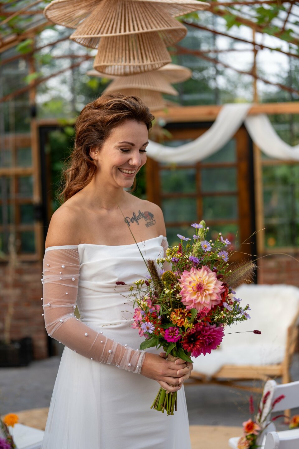 een vrouw in een witte jurk met een boeket bloemen