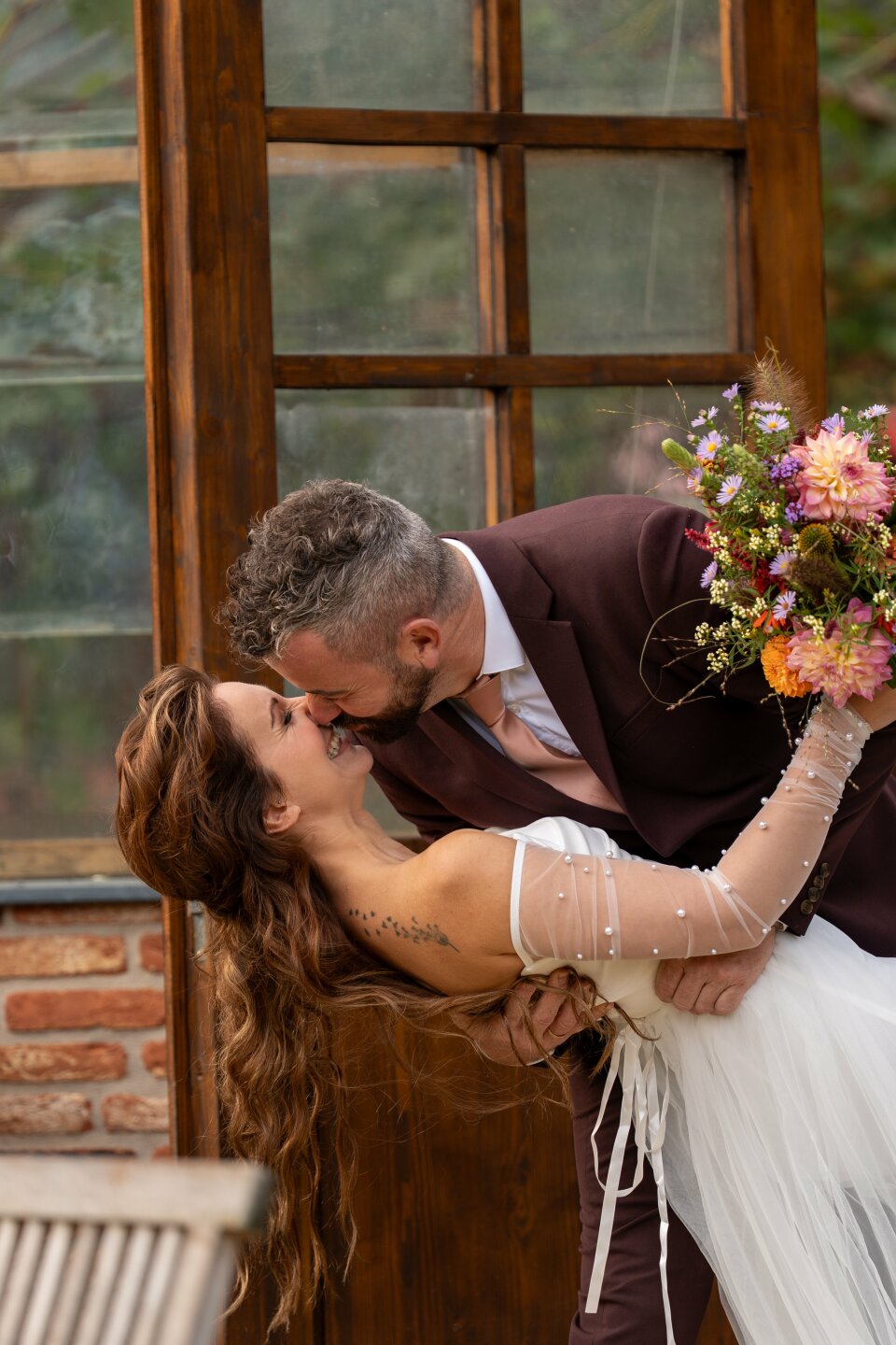 een man die een vrouw in een trouwjurk kust