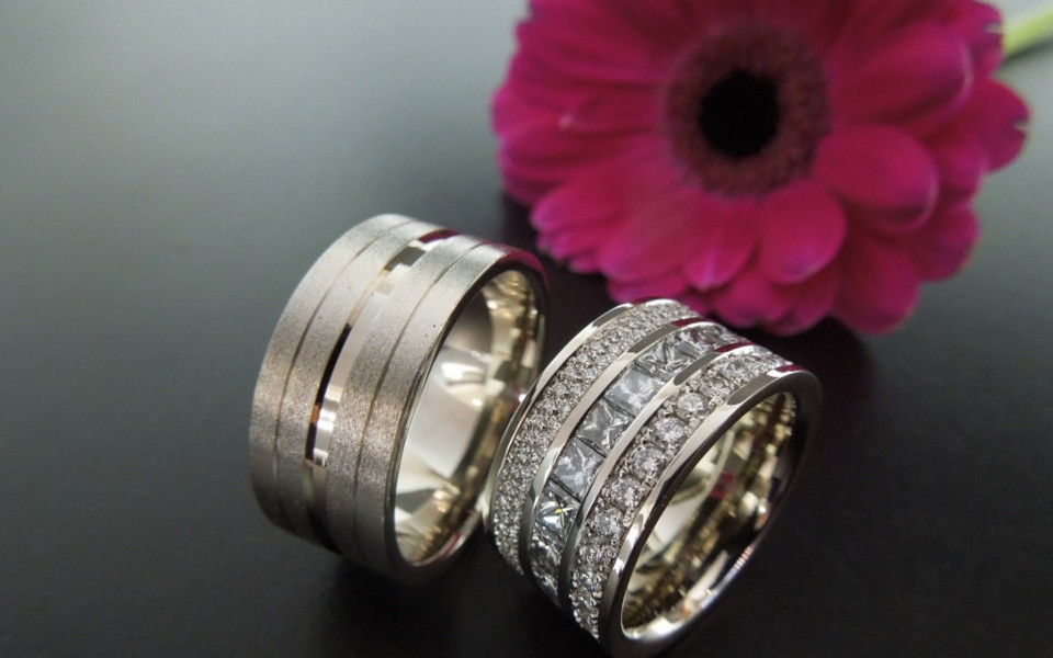 twee trouwringen met diamanten op een tafel