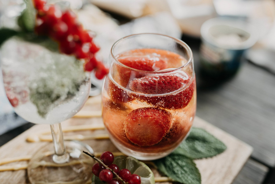 een glas wijn met aardbeien en munt