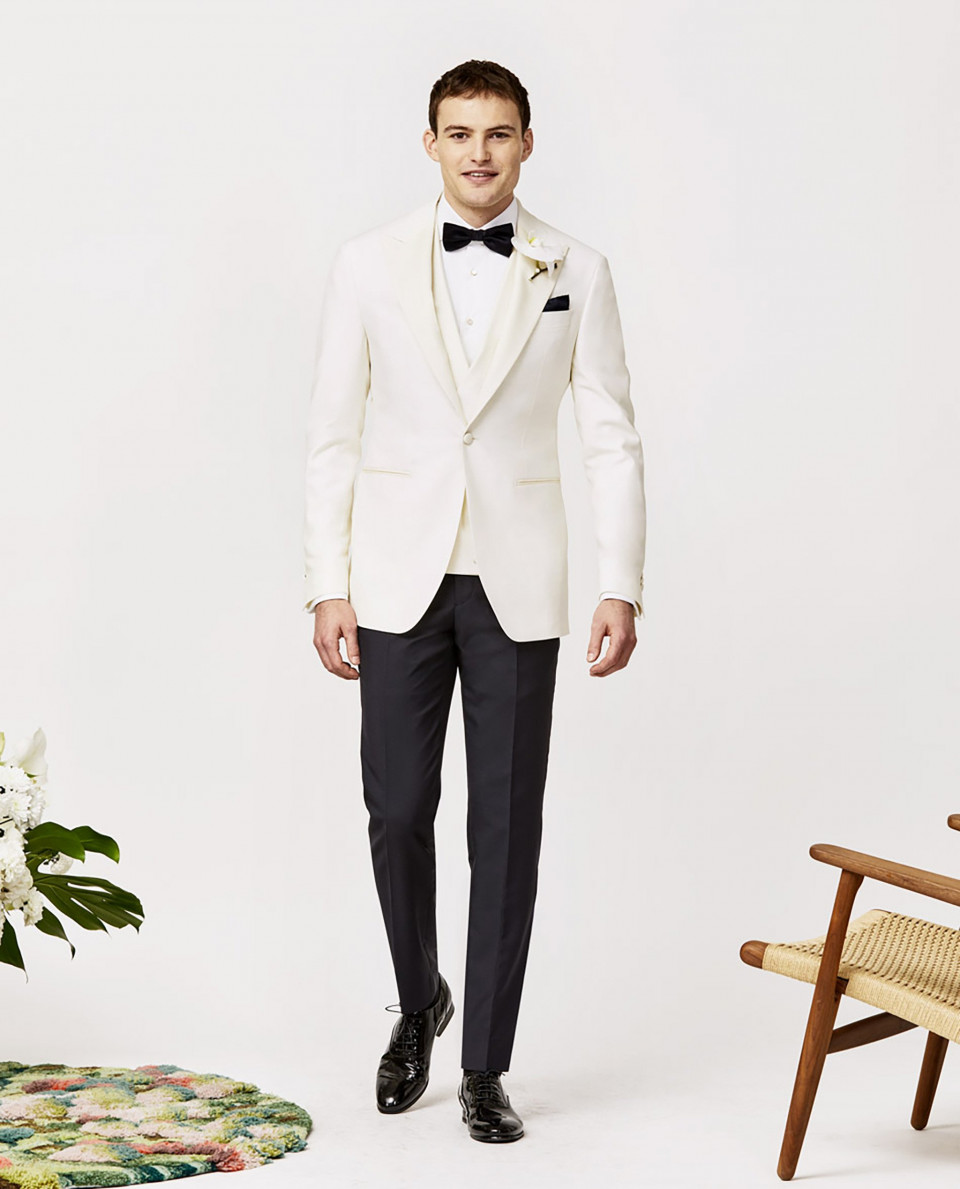 een man in een witte smoking en vlinderdas