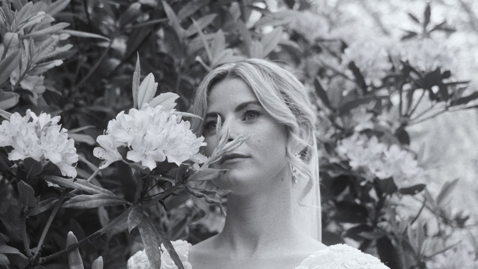 een vrouw in een trouwjurk staat voor wat bloemen