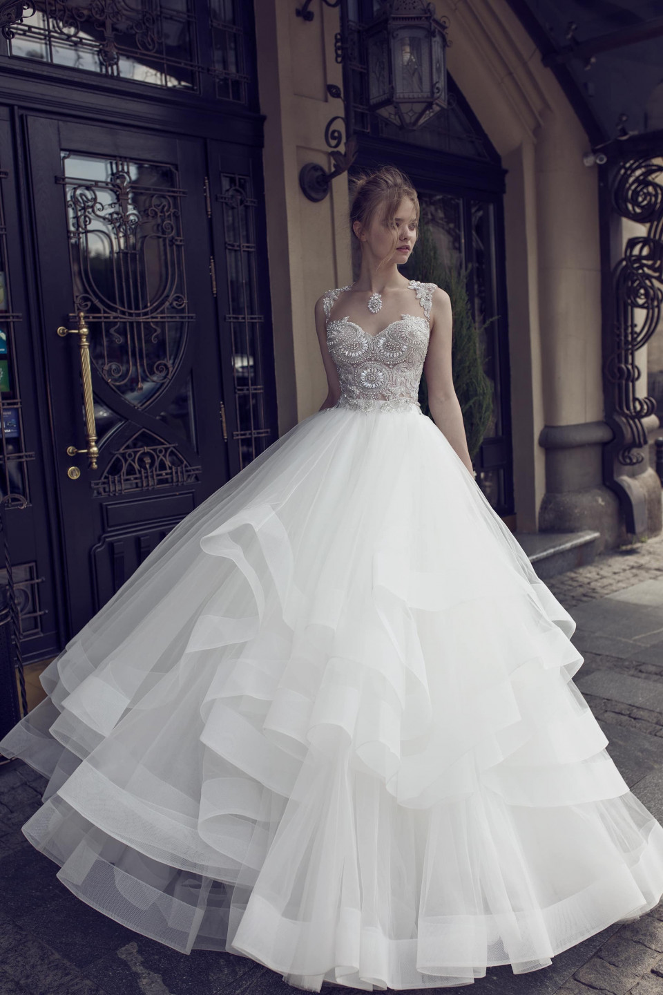 een mooie bruid in een trouwjurk staat buiten