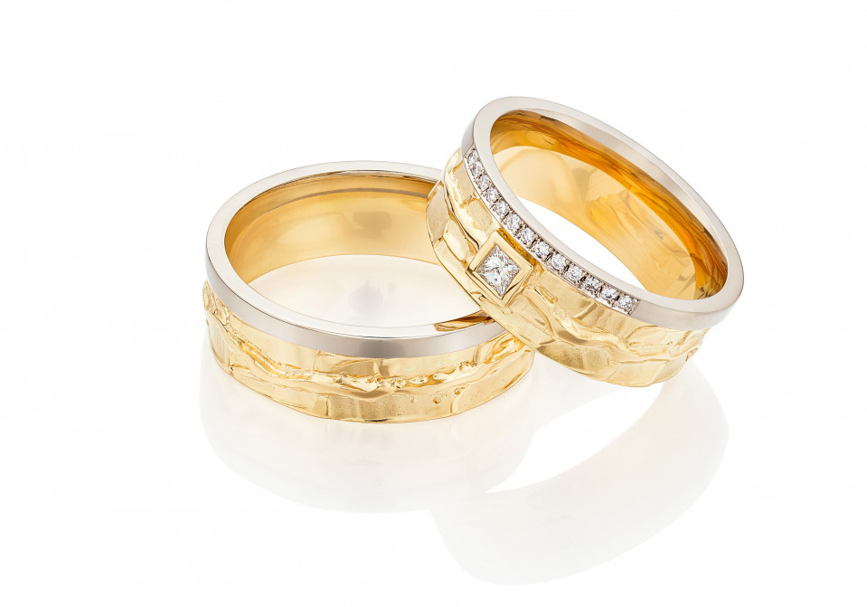 twee trouwringen met diamanten in goud en zilver