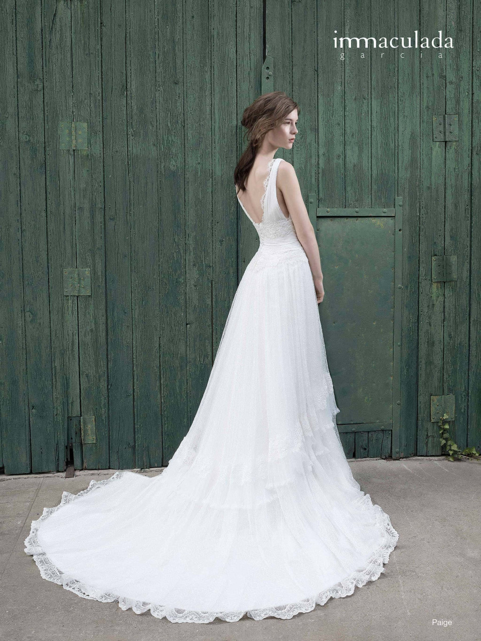 een vrouw in een trouwjurk staande voor een groene deur