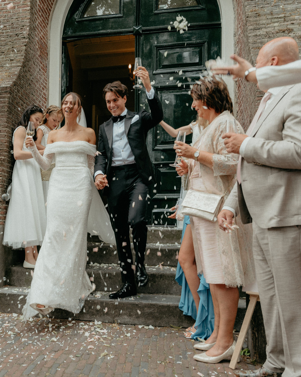 een bruid en bruidegom lopen de trappen van een kerk af