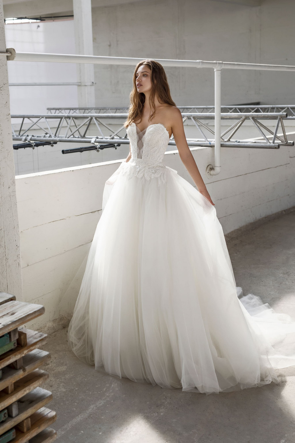 een vrouw in een trouwjurk die in een magazijn staat