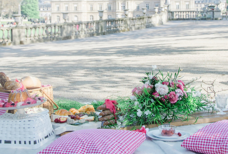 een picknicktafel met een roze en wit geruit tafelkleed
